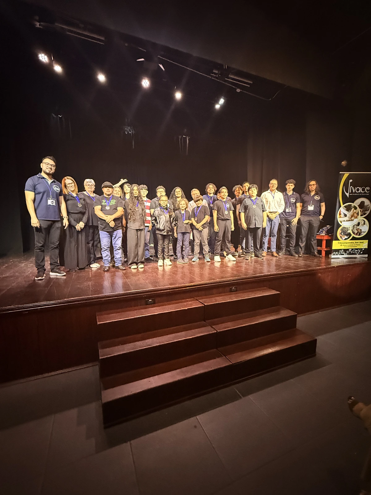 Estudiantes y profesores de Academia Vivace en el escenario durante un evento de la academia